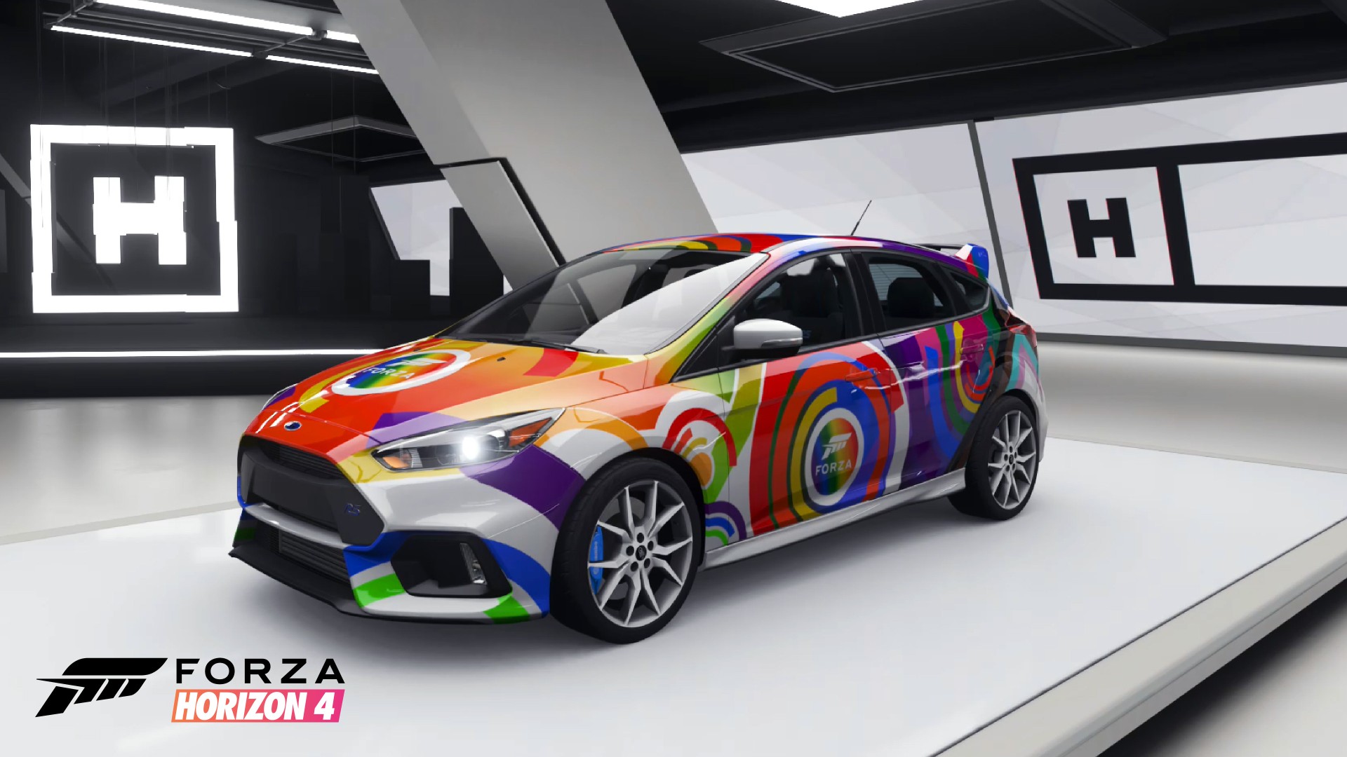 The 2017 Ford Focus RS, decorated with a colorful rainbow circle pattern, is parked at an angle facing the viewer in Forza Horizon 4.