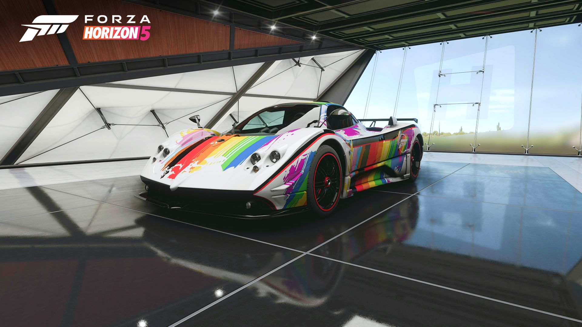 A 2009 Pagani Zonda Roadster is parked inside a sleek garage at the Horizon Festival. Its white body is painted with bold, graphical stripes in all colors of the rainbow, correlating to the colors of the Pride flag.