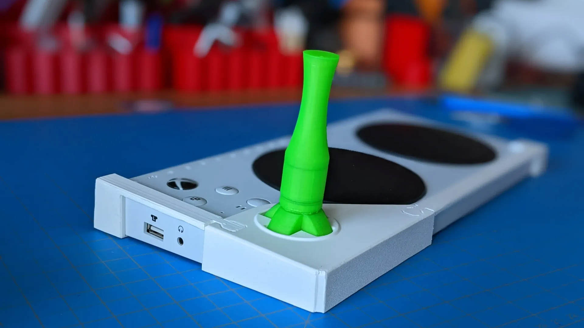 A 3D-printed joystick attachment connected to an Xbox Adaptive Controller.